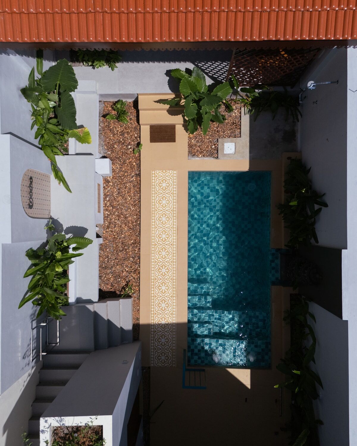 The pool seen from above, enclosed by white walls and planting.